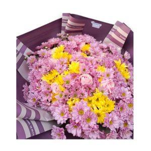 Vibrante ramo de flores frescas en tonos rosados y amarillos, envuelto en papel decorativo púrpura, ideal para regalar en ocasiones especiales.