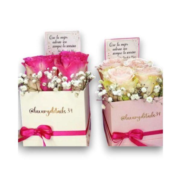 Una caja como base con una lazo decorativo y cuatro rosas, podrá incluir una tarjeta dedicatoria.