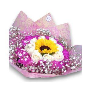 Ramo de rosas de color blanco y morado, en el centro un girasol con un lindo envoltorio decorativo con detalles