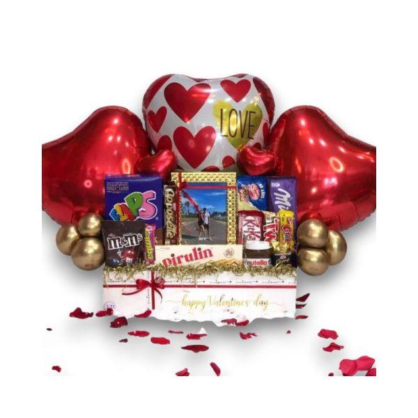Hermoso arreglo para demostrar tu amor, contiene un cuadro para una fotografía, globos decorativos y ricos dulces para deleitar.